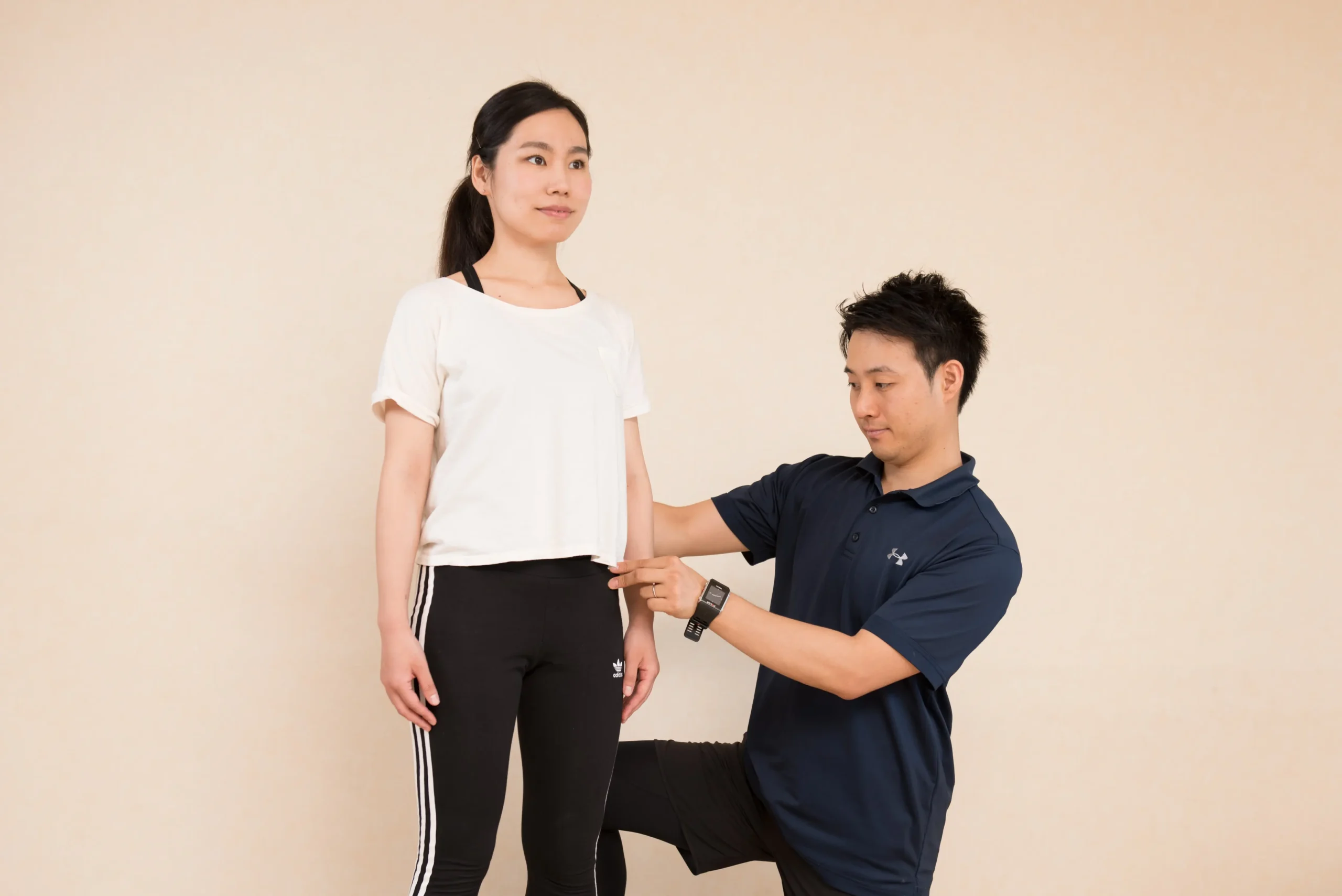 トレーナーから身体の状態のチェックを受ける女性