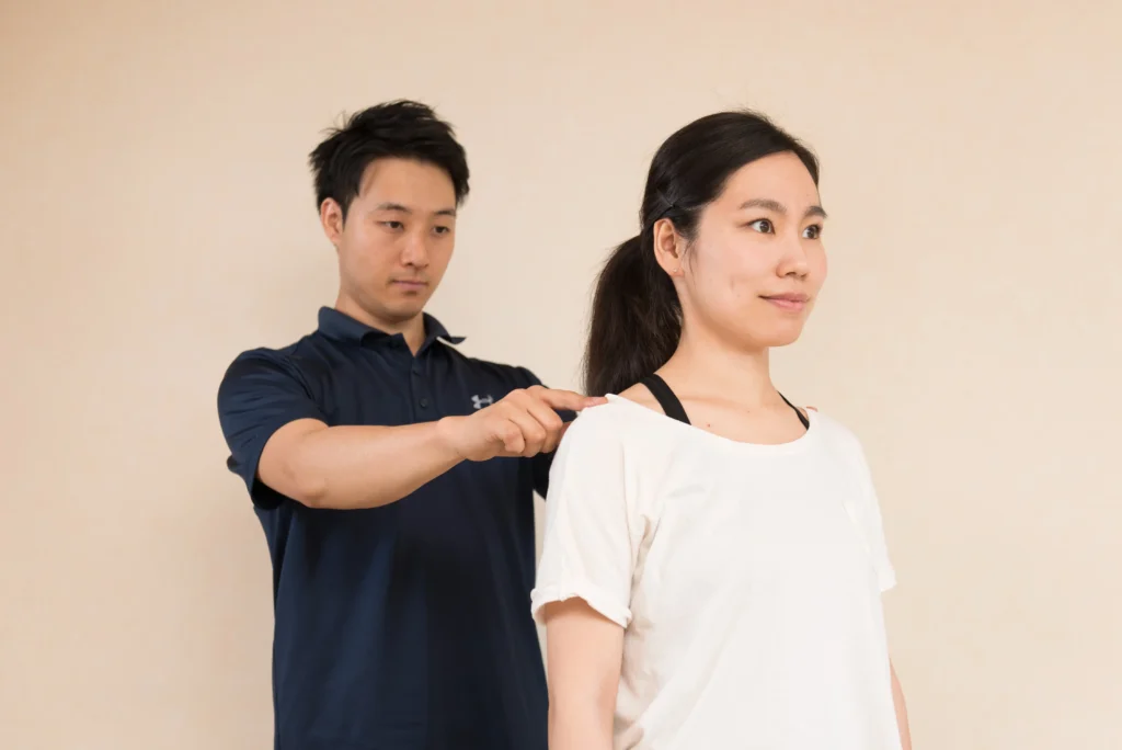 姿勢のチェックをトレーナーにしてもらっている女性
